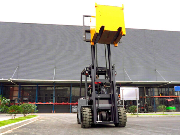 Duży, elektryczny wózek widłowy Q-LIFT by WDX serii CPD podczas pracy z uniesionym masztem